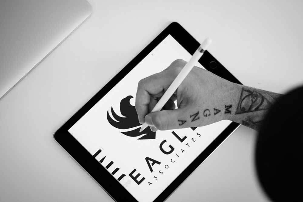 A creative male artwork designer drawing a company logo on an iPad.